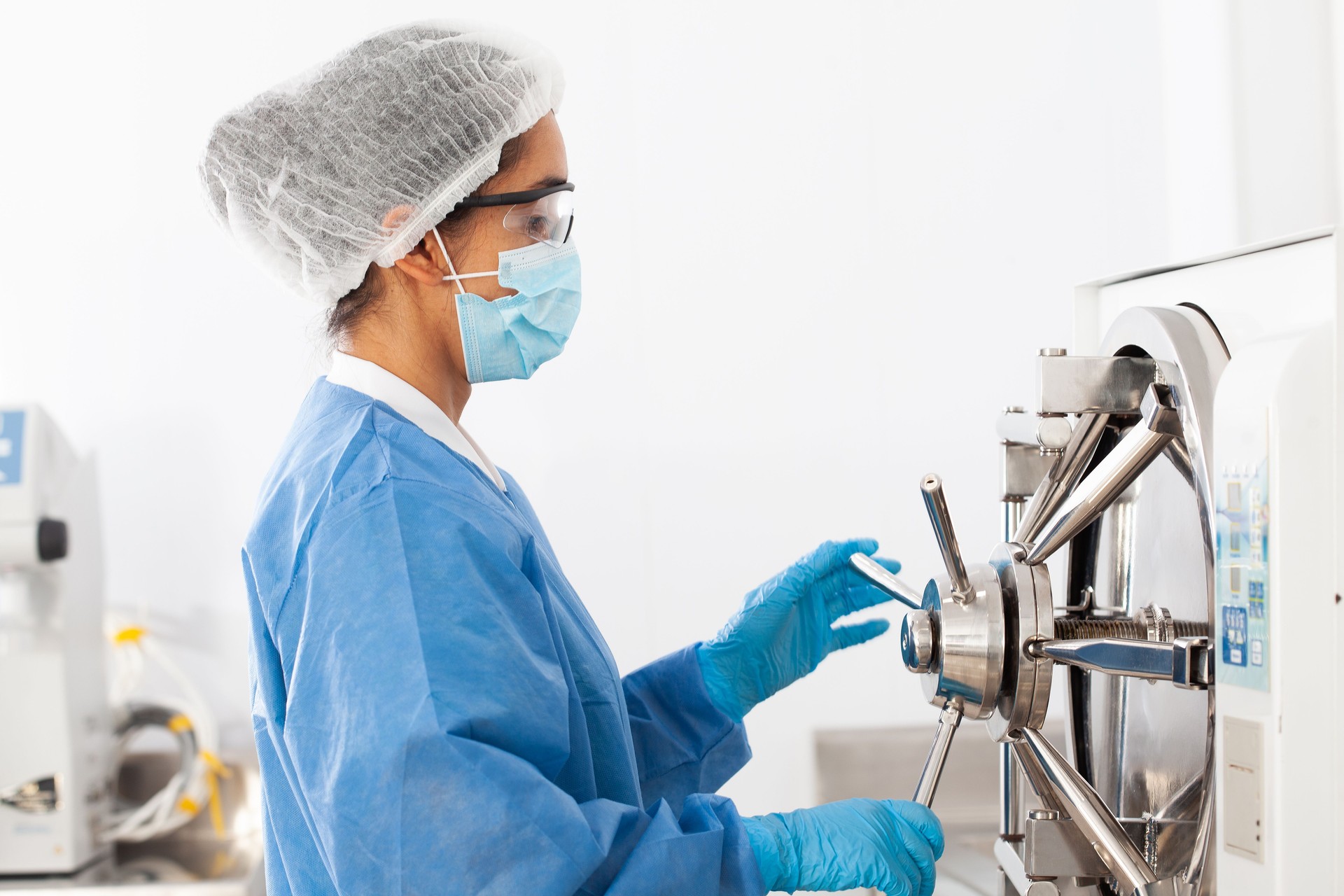 Young female scientist sterilizing laboratory material in autoclave